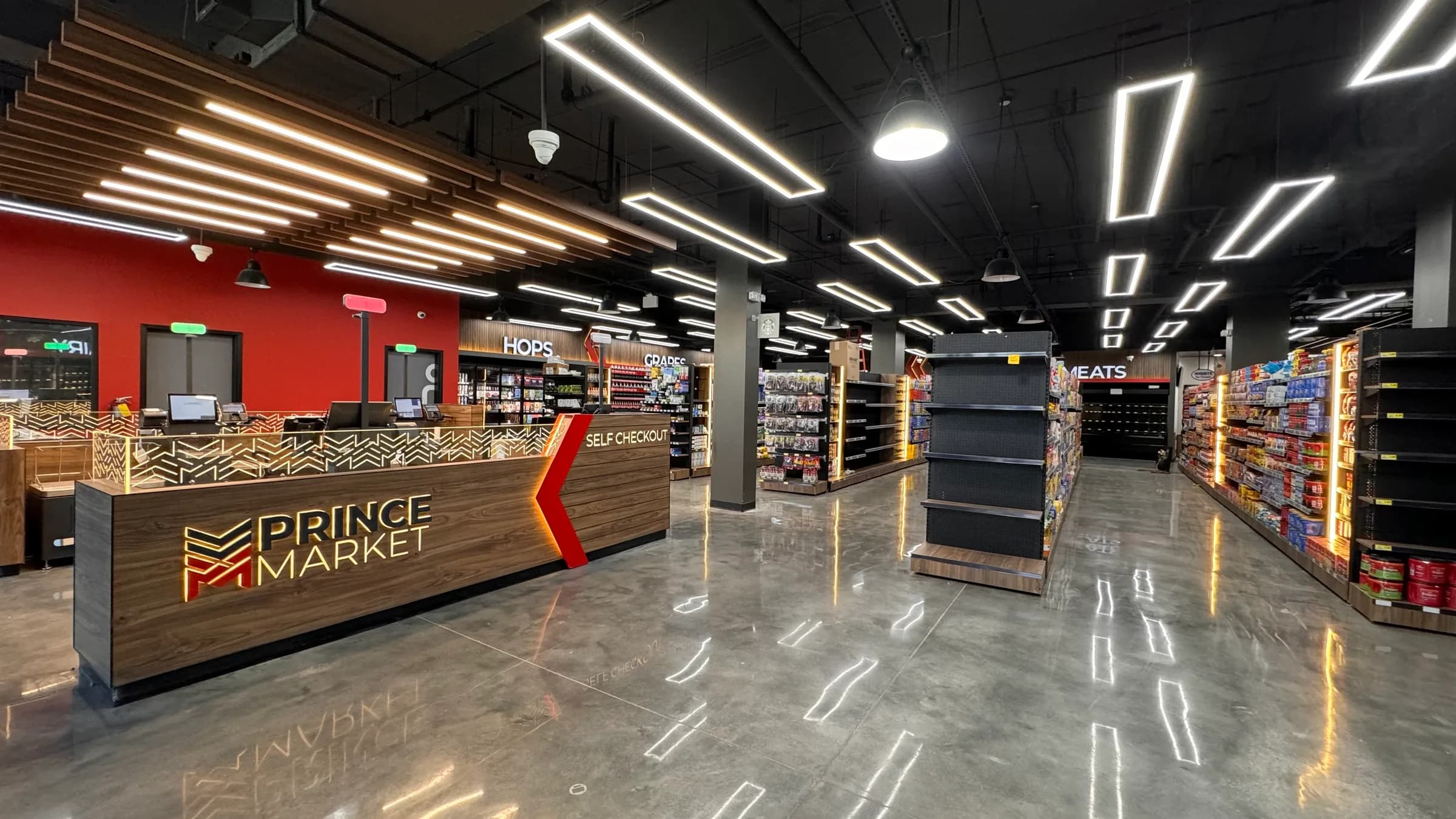 Prince Market grocery store with a wood self-checkout counter, linear lighting and stocked aisles